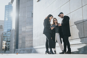 Three young entrepreneurs are engaged in a discussion with digital tablet outdoors. Dynamic...