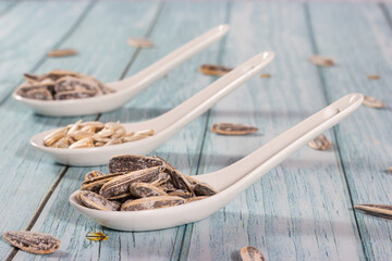 Close-up of sunflower seeds in ceramic teaspoons. Healthy snacks.