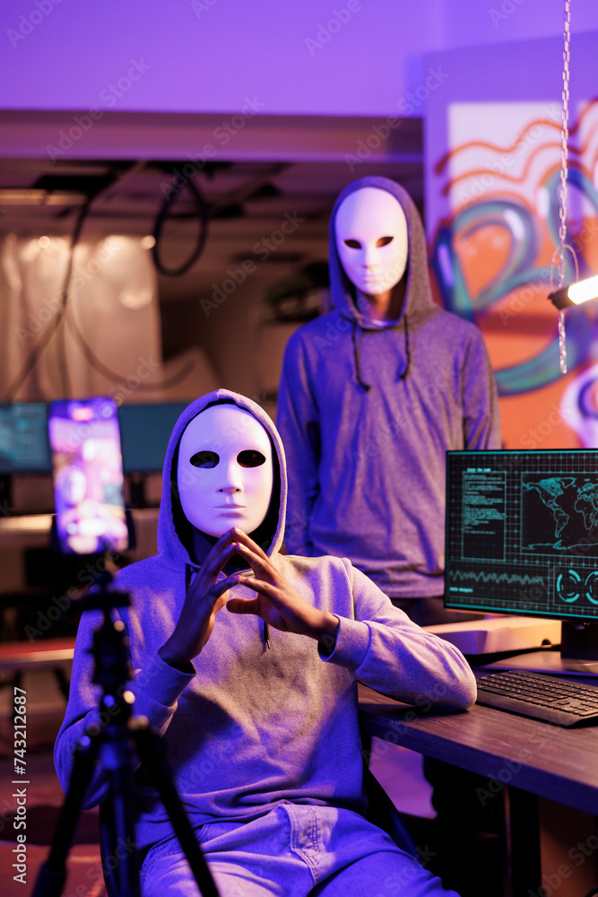 Poster scammers in anonymous masks streaming threat online and demand victim for payment. hackers with hidd