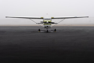 High-Wing Propeller Aircraft parked in fog - front view