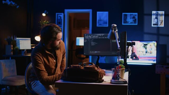 Freelancing system administrator arriving in personal office at home, resuming work on coding. IT expert starting job in apartment, writing lines of code on computer, camera B panning shot