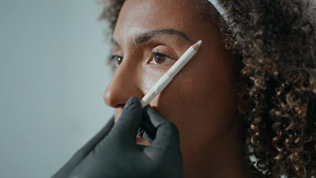 Closeup cosmetologist marking botox injection site. Woman visiting beauty salon