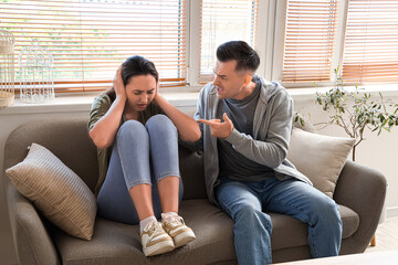 Young man quarreling with his wife at home