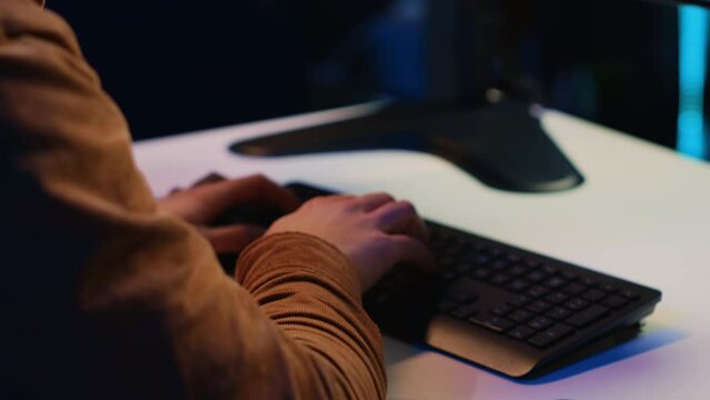 Computer scientist listening music while writing lines of code during remote job shift in home office. IT specialist enjoying audio podcast, coding on desktop PC, camera A extreme close up