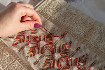 Close-up of woman embroidering on etamine fabric. Huck embroidery. 