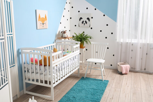 Interior of stylish children's bedroom with crib and pictures