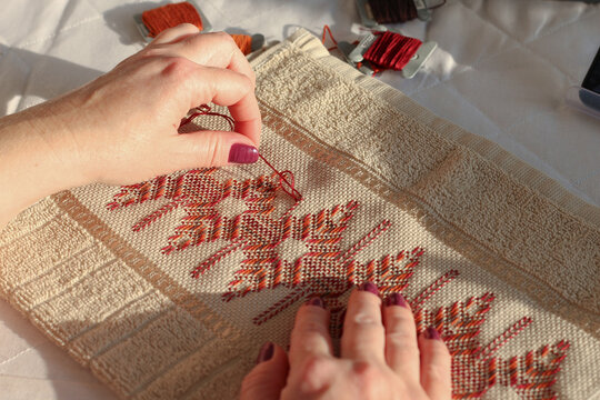Close-up of woman embroidering on etamine fabric. Huck embroidery. 