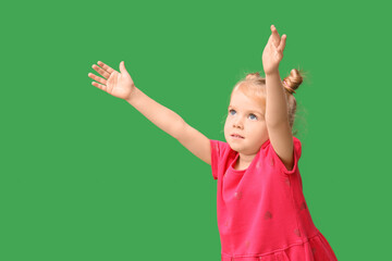 Cute little girl opening arms for hug on green background