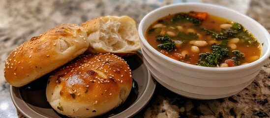 A plate holding a bowl of nourishing white bean and kale soup, paired with two dinner rolls. The soup is steaming and the rolls are fresh and fluffy, ready to be enjoyed.