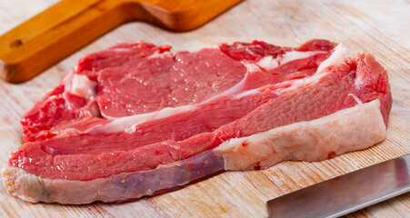 Ingredients for cooking. Fresh raw beef entrecote on wooden cutting board