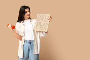 Young woman with dumbbell and sign GRL PWR on beige background. Feminism concept