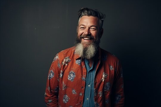 Portrait of a happy middle-aged man with long gray beard and mustache in a shirt on a dark background