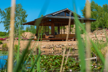 Japanese tea house near a pond with water lilies and willows. Japanese style gazebo.Tea ceremony...