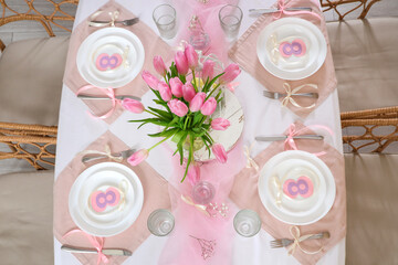 Dining table with setting and beautiful tulips served for International Women's Day celebration - obrazy, fototapety, plakaty