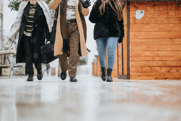 Group of business colleagues bundled up in winter attire walking on a snowy sidewalk, with a...
