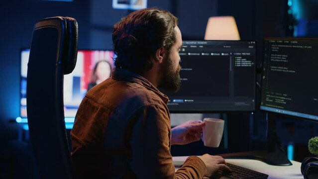 Stressed engineer feeling pressed by deadline, thinking how to finish developing code on PC. IT specialist brainstorming ways of solving database errors, working hard, drinking coffee, camera A
