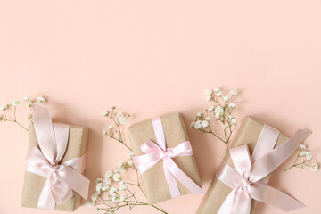 Festive wrapped gift boxes decorated with flowers on beige background