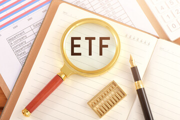 The magnifying glass on the chart is printed with the letter ETF