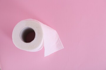 Soft toilet paper roll on pink background, top view. Space for text