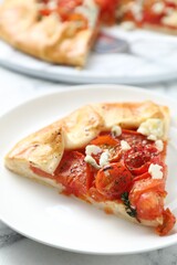 Tasty galette with tomato and cheese (Caprese galette) on white marble table, closeup