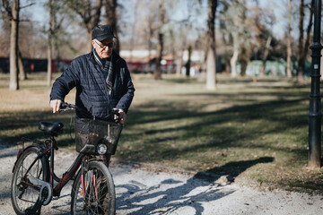 Senior man enjoying a sunny day in the park with his vintage bicycle.