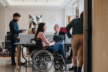 A modern office setting with multicultural team members and a colleague in a wheelchair, emphasizing diversity and inclusion at work.