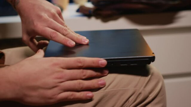 Freelancing computer scientist starting work in personal office at home, taking laptop out of bag. Self employed admin unpacking backpack, writing on notebook keyboard, camera A close up shot