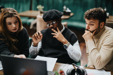 Multiethnic group of business partners working together in a casual restaurant setting, using...