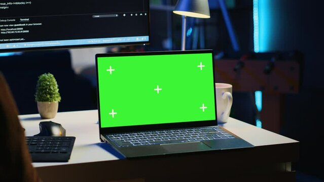 Green screen laptop in home office used for developing software applications. Mockup notebook used by teleworking IT specialist for programming, camera A close up panning shot
