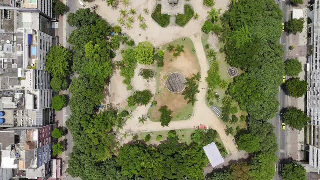 Aerial shot drone flies forward with camera straight down over large park with pond