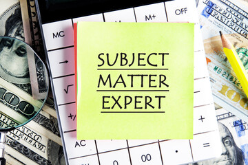 Text Subject Matter Expert writtenon a yellow sticker on the calculator against the background of...