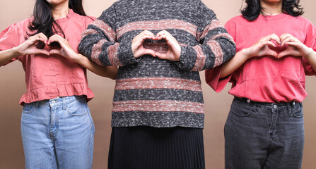 Group of women showing heart figure with fingers, celebrating women's day