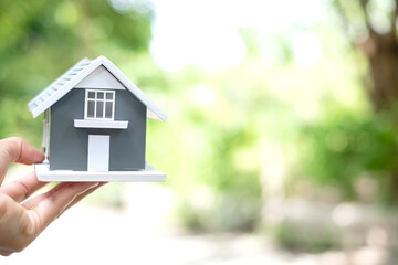 Obraz na płótnie Canvas Hand-holding house model. Home insurance concept