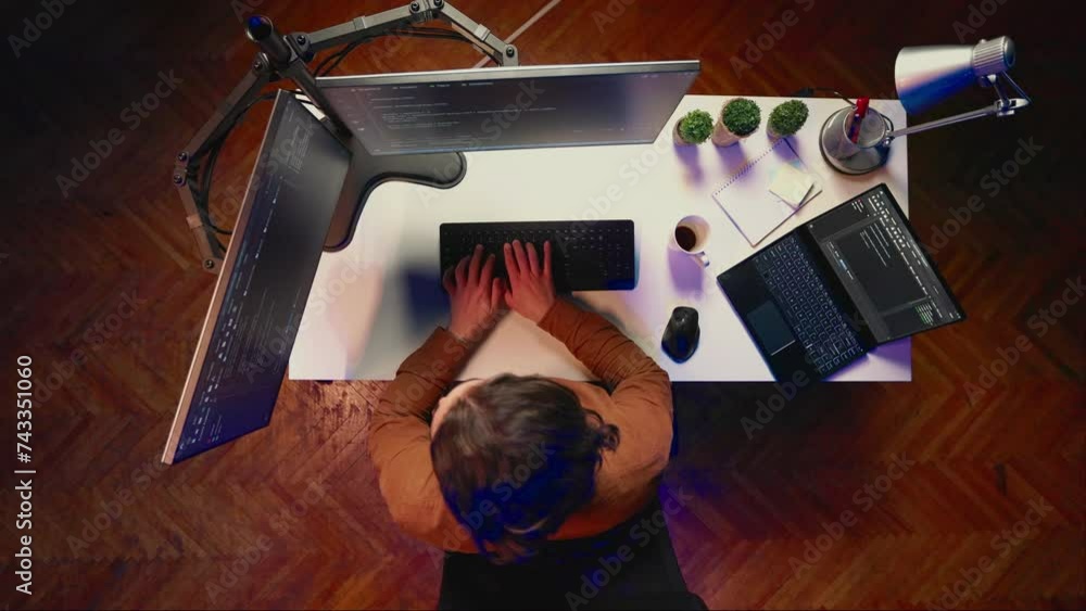 Poster top down view of technician puts headphones on while fortifying firewalls, teleworking for it compan