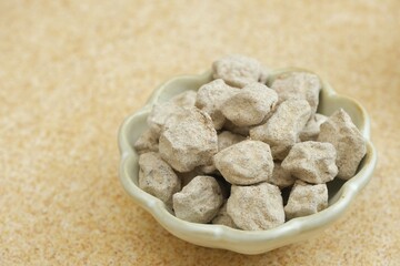 Isolated Kiamboy in bowl with brown background. Kiamboy is preserved of dehydrated plum with taste...