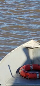 Proa de lancha en el r&iacute;o con salvavidas naranja.