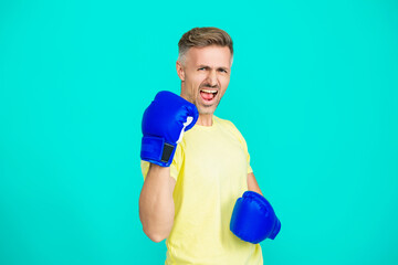 Strong athlete man. Sportsman in gym. Strong boxer in sportswear. Exercising and punching. Practicing boxing. Sportsman in boxing gloves isolated on blue. Mature man boxer fighter. Sport man boxing