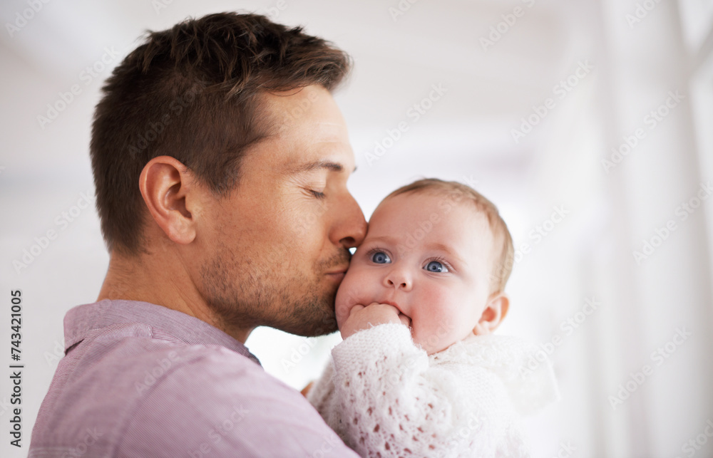 Wall mural Love, father and baby with kiss in home for affection, comfort and bonding together for healthy development. Family, man and newborn child with hug, embrace and relax for parenting, care and security