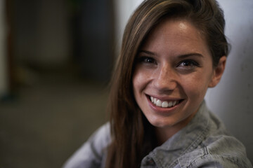 Positive, female person and happy portrait of student, casual and hopeful girl against wall. Brazil, woman and dark background in home, feeling joy and stress free, confident and proud smile