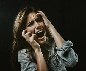 Portrait, mental health and horror with woman screaming in studio on black background for reaction...