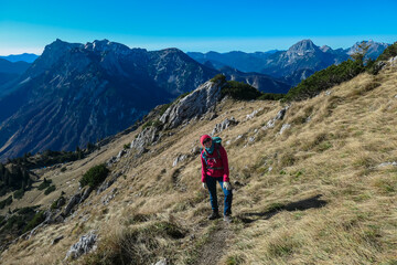 Fototapeta na wymiar Hiker woman with scenic view of majestic mountain peaks of Gesäuse seen from Hochblaser in Eisenerz, Ennstal Alps, Styria, Austria. Idyllic hiking trail in remote nature in summer. Wanderlust concept