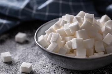 White sugar cubes in a blue bowl on the table