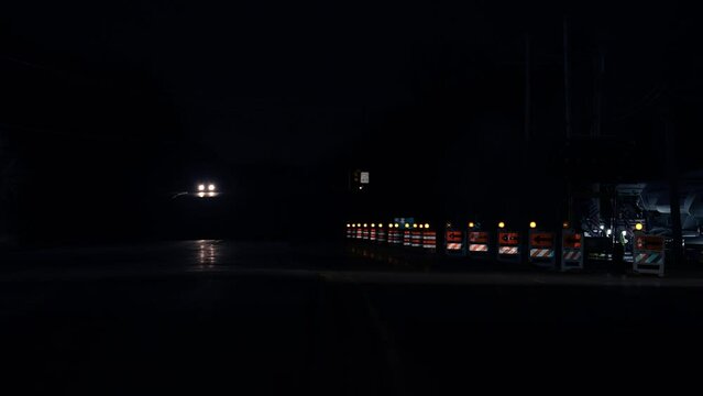 Warning signs for work in progress on road under construction. Night traffic passing by a warning sign
