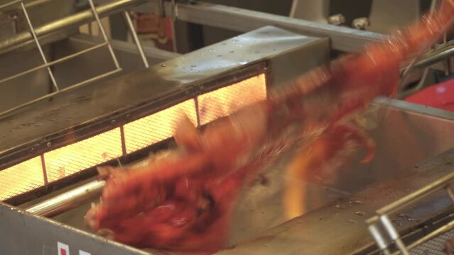 Piglets are being roasted on the stove by turning them around.