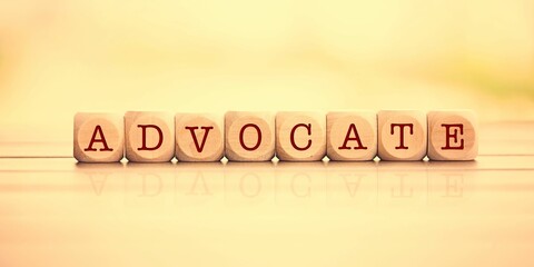 "ADVOCATE" word made with building wooden blocks on wooden background
