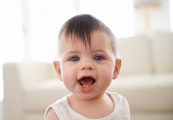 Portrait, face and cute toddler in living room of family home, innocent and young child in apartment. Teeth, joy and infant boy, youth and happiness for baby, growth and development in house