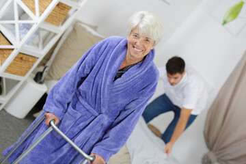 elderly woman using zimmer frame in the home