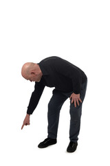 Naklejka premium side view of a crouching man pointing finger at the ground on white background