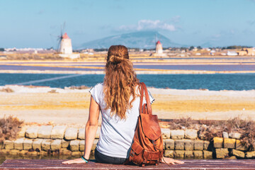 Woman tourist in Marsala, sea salt with typical windmill- Sicilia in Italy