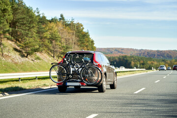 Transporting Bicycles by Car for a Vacation. A Vehicle with a Bike Carrier and a Rear Rack on the...